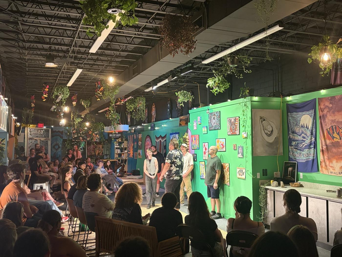 Improvisers on the rug at NatureBacks with the audience packed in